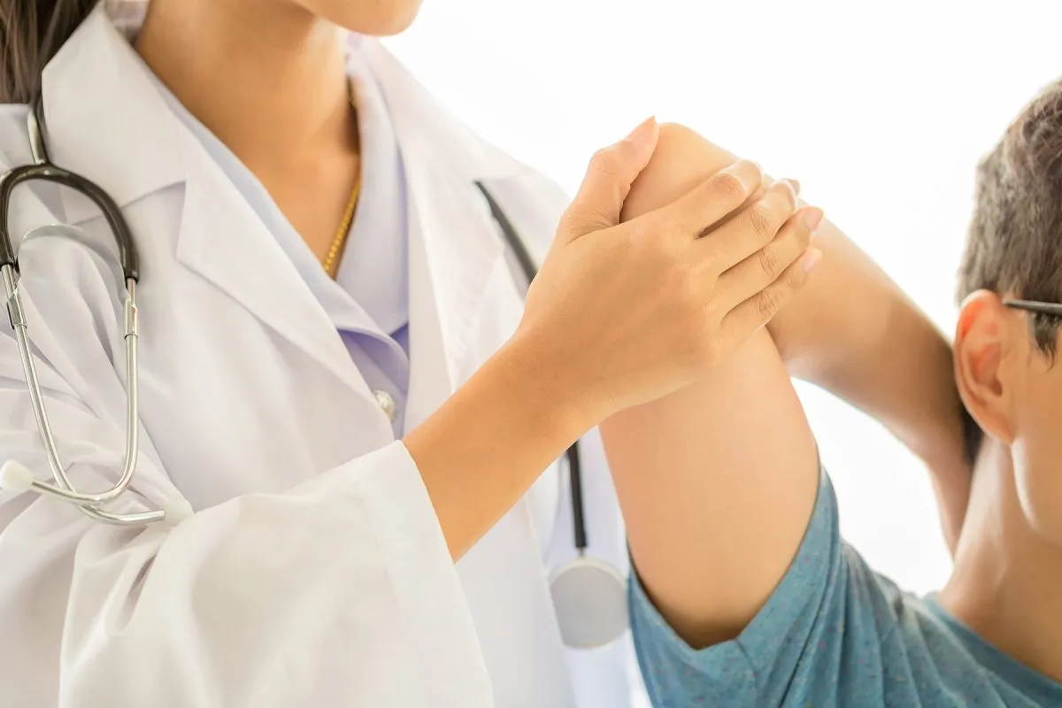 Reumatologo esegue visita reumatologica valutando le articolazioni del paziente a Treviso
